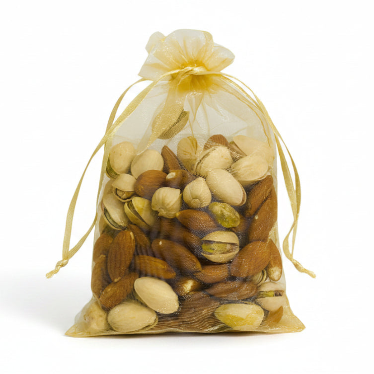 Assorted nuts in a gold drawstring bag on a light gray background