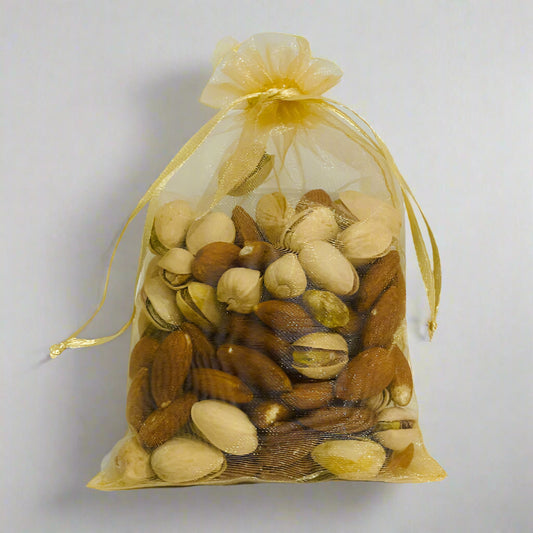 Assorted nuts in a gold drawstring bag on a light gray background